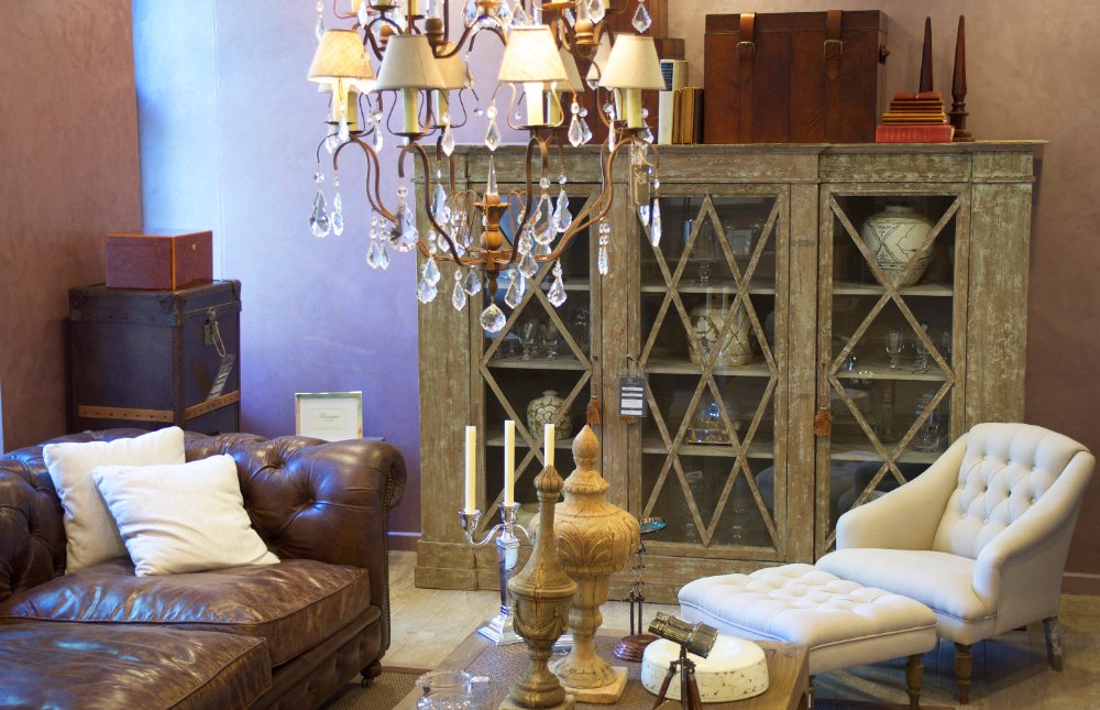 Sofá de couro marrom, com textura rica, situado em uma sala de estar, proporcionando um ambiente charmoso e aconchegante cheio de estilo.